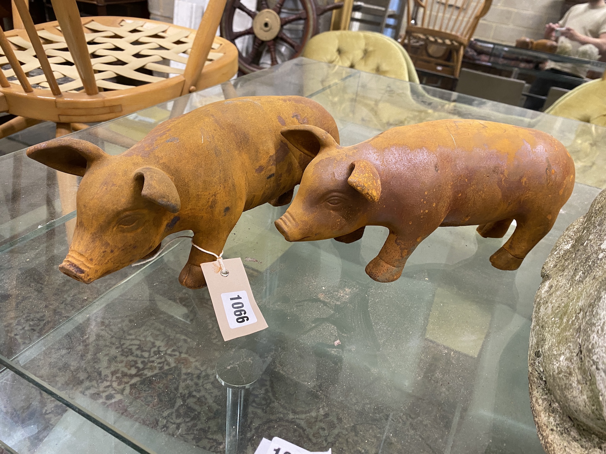 A pair of cast metal garden pig ornaments and a cast stone cat and rabbit ornament, largest length 34cm